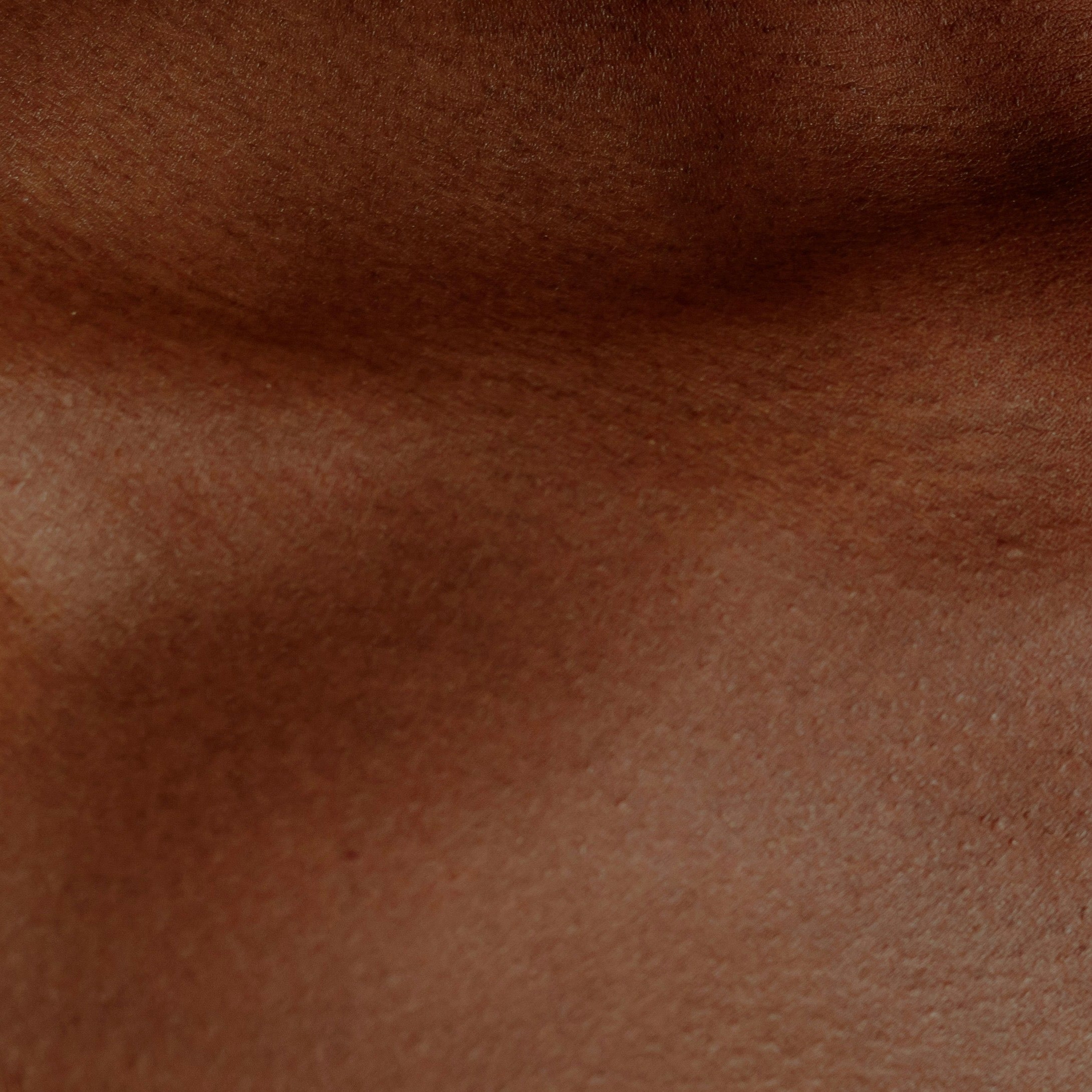 Photo macro d’une peau naturelle – texture douce et lumière chaude illustrant la pureté et l’hydratation des soins 1+3