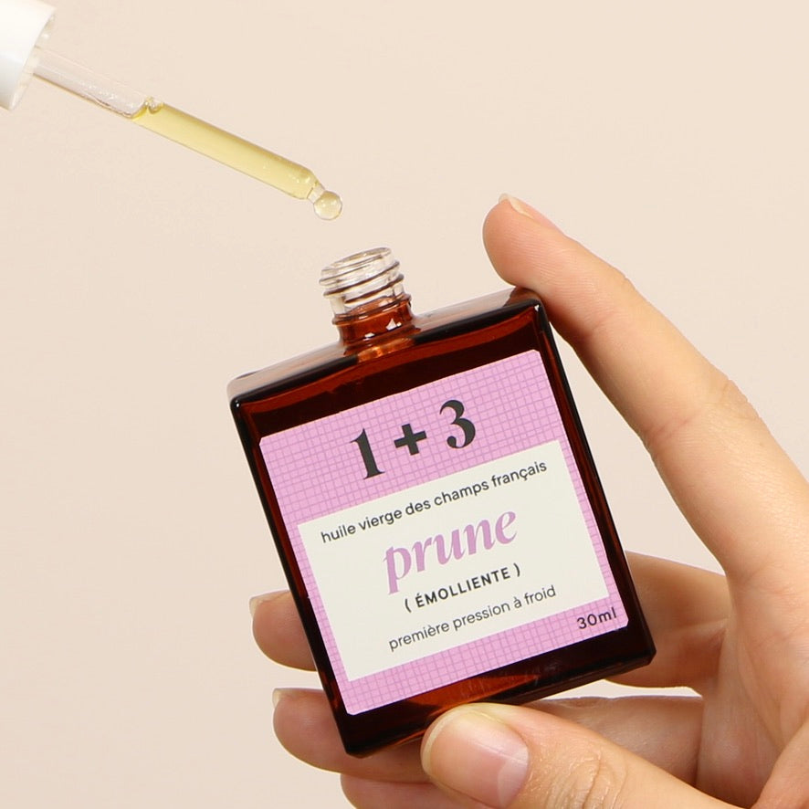 Mains tenant l’huile de prune 1+3 – émolliente et protectrice, adoucit les peaux sèches
