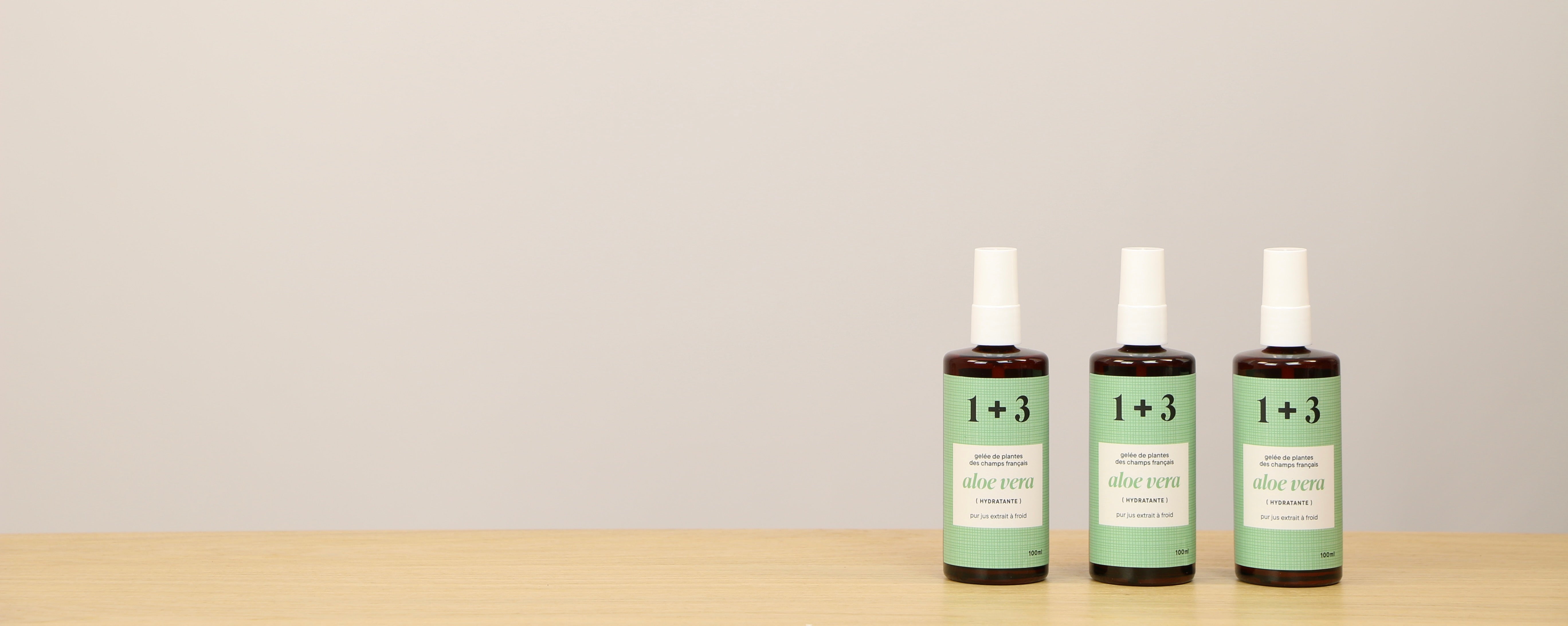 Trois flacons de gelée d’aloe vera 1+3 alignés sur une table – soin hydratant français au pur jus extrait à froid