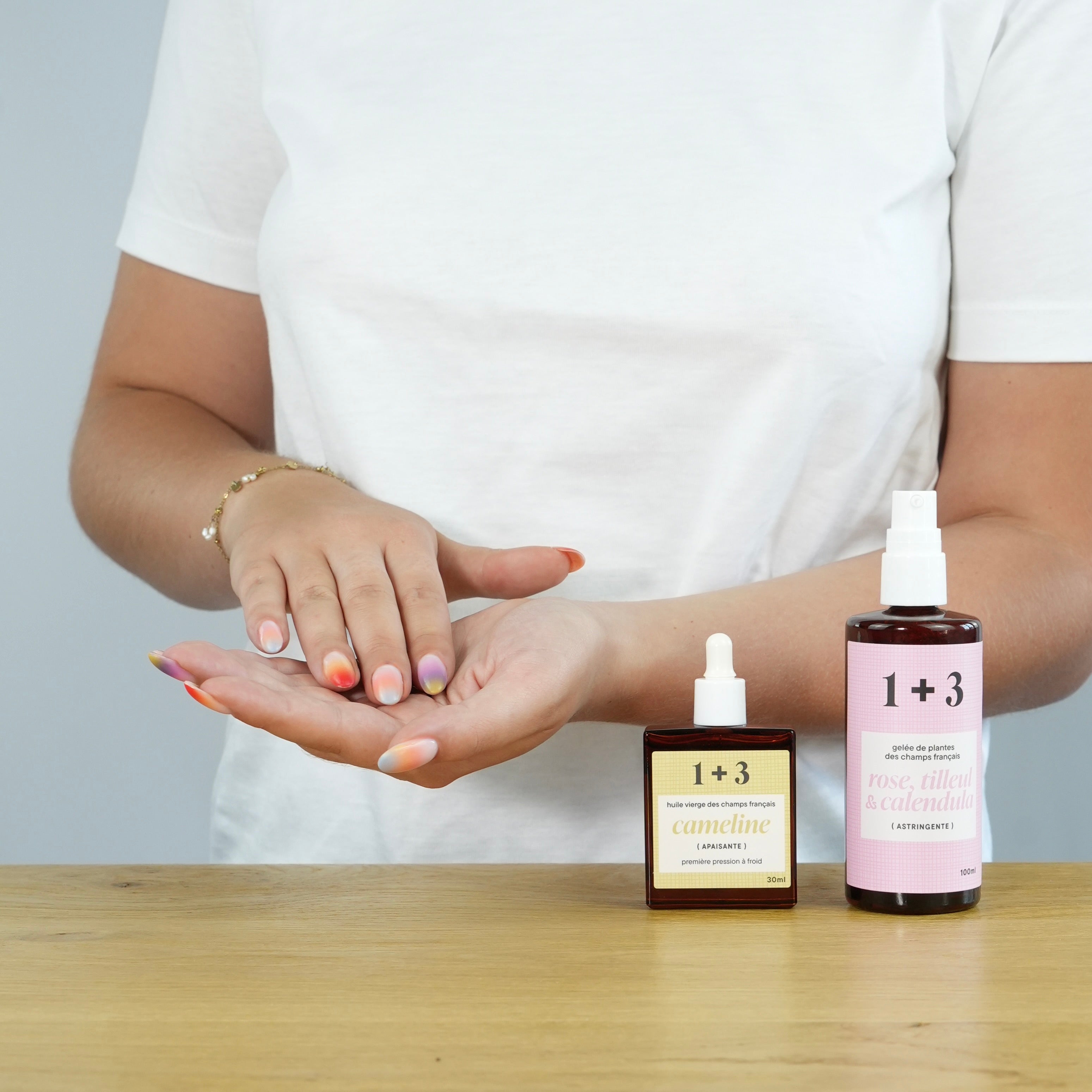 Marine mélange l’huile de caméline et la gelée de rose, tilleul et calendula dans sa main – création du soin 1+3