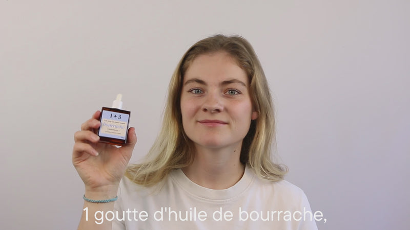 Églantine réalise la méthode 1+3. Elle dépose une goutte d’huile de bourrache et trois gouttes de gelée rose, tilleul & calendula dans sa main, mélange puis applique le duo sur sa peau.